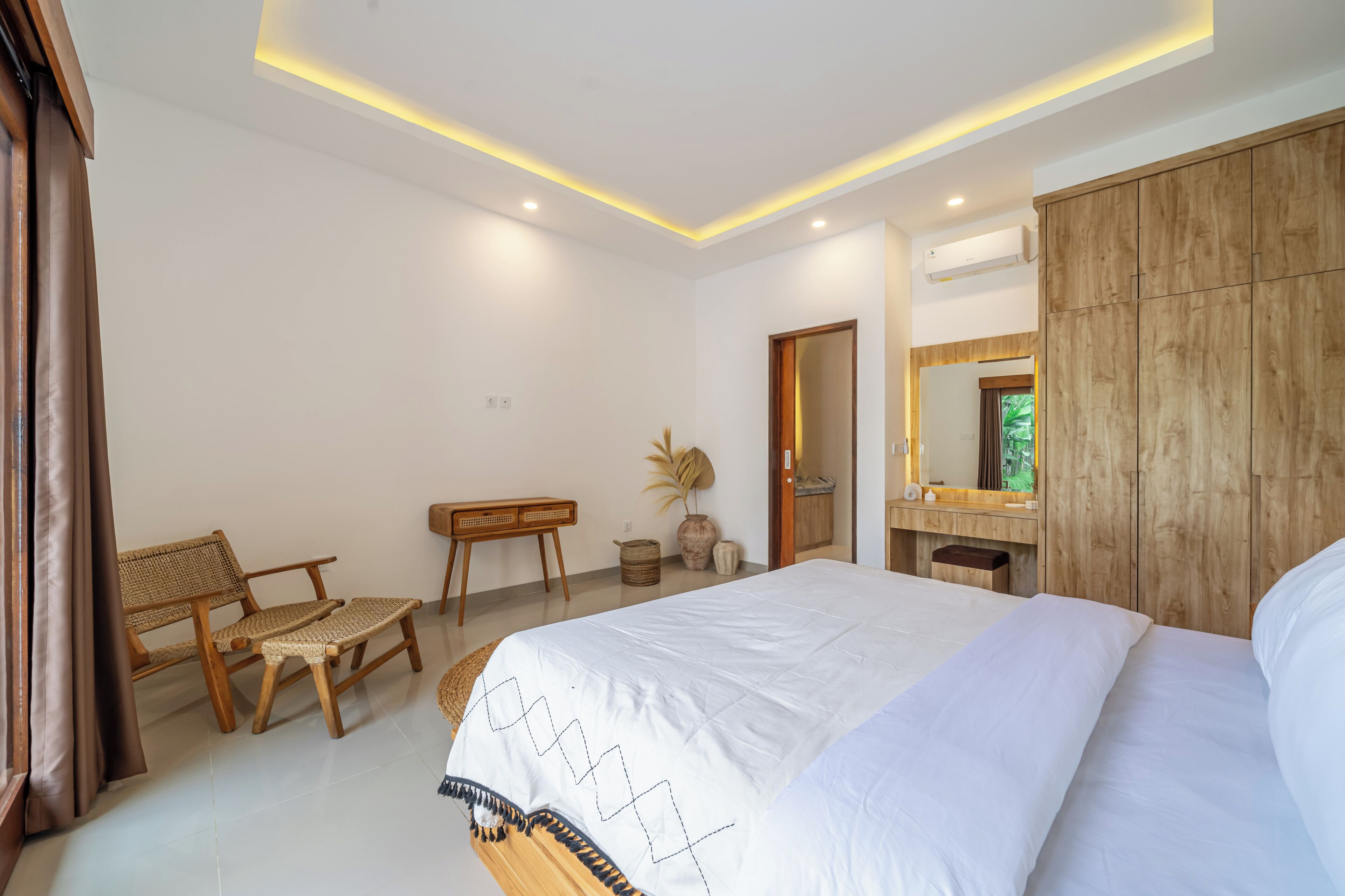 Un dormitorio con cama, armario de madera, mesita de noche y espejo.