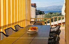 Ein Balkon mit Tisch, Stühlen und einer Obstschale.
