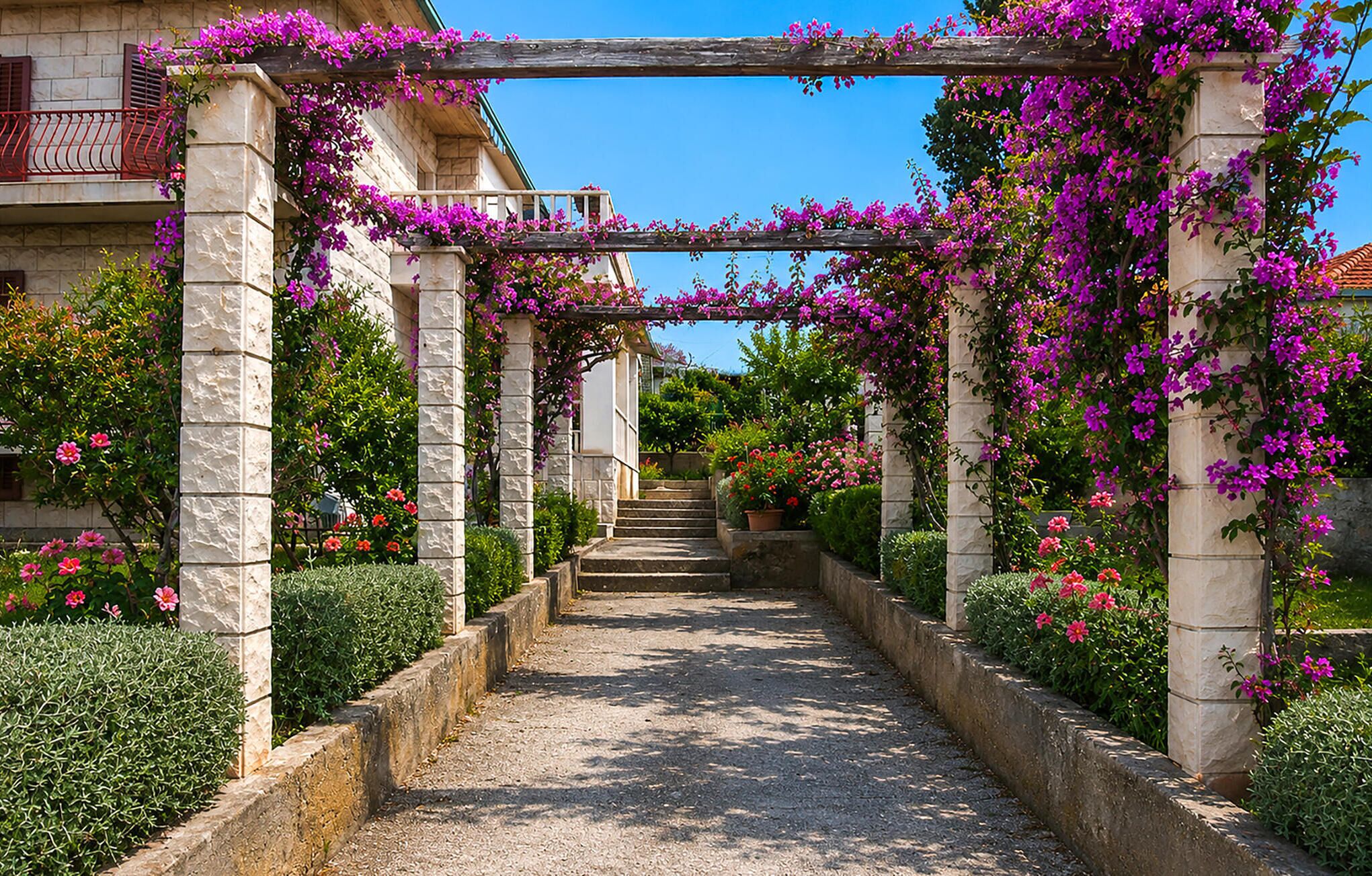 A stone pathway leading to a building with a wooden pergola covered in purple flowers.