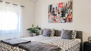 A bedroom with a bed, a potted plant, a wall art piece, and a window with curtains. - 2 bedroom stunning home in Selca (Selca)