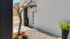 A modern building with a stone facade, a door with a number, and a gravel pathway. - 2 bedroom stunning home in Selca (Selca)