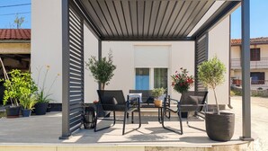 An outdoor patio with a pergola, seating, potted plants, and a view of a residential building. - 2 bedroom stunning home in Selca (Selca)