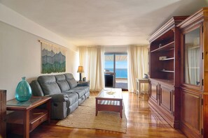 Ein Wohnzimmer mit einer Couch, einem Couchtisch und einem Holzschrank.