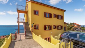A yellow building with a staircase, a balcony, and a view of the sea. - Lovely apartment in Crikvenica (Crikvenica)
