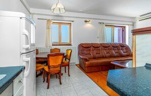 Ein kompakter Wohnraum mit Küchenzeile, Essbereich und einer Couch.