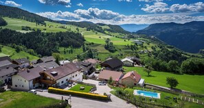 Un hotel rural con varias construcciones, una piscina y vistas al campo circundante.