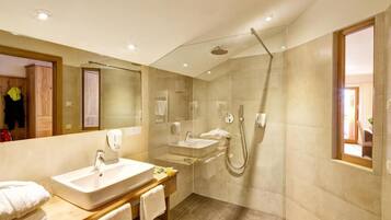 Un bagno moderno con un grande specchio, due lavandini, una doccia e un mobile bagno in legno.