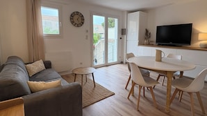 Ein Wohnzimmer mit einer Couch, einem Couchtisch und einem Fernseher.