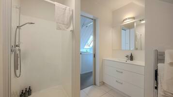Een moderne badkamer met een douche, toilet en wastafel.