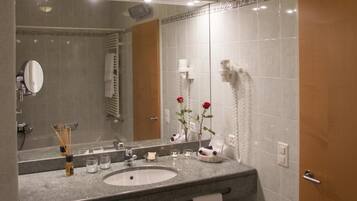 A bathroom with a sink, mirror, and towel rack.