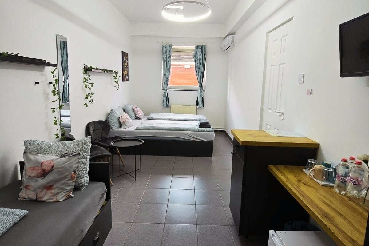 A compact room with a bed, a desk, a chair, and a TV.