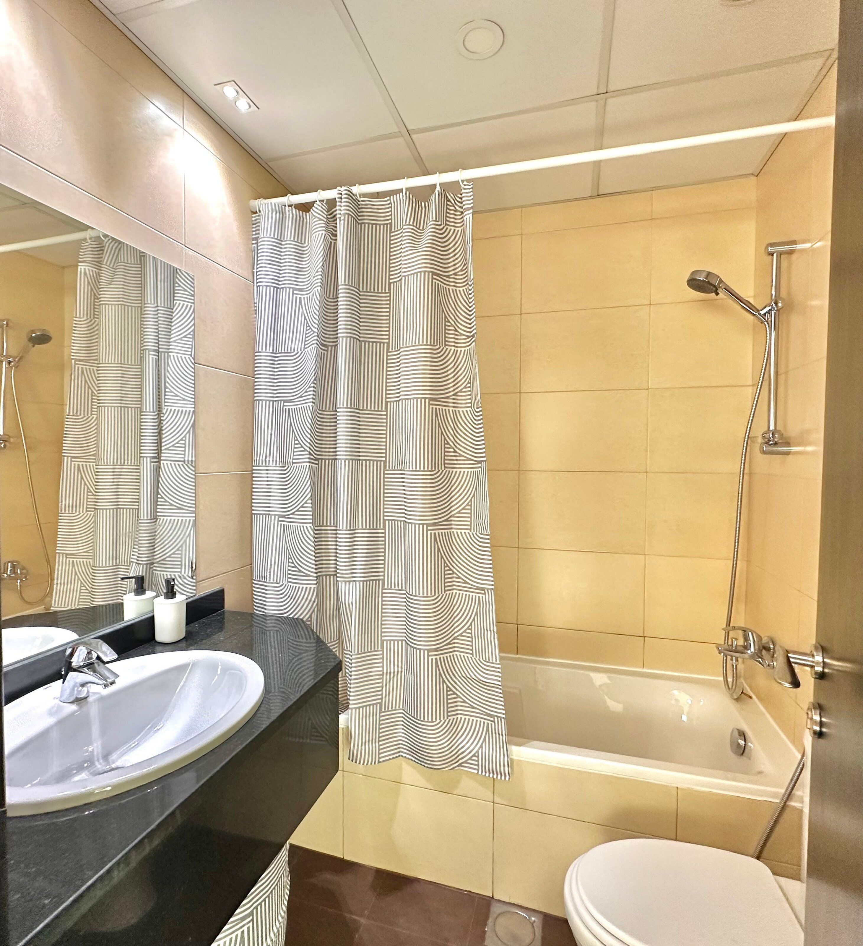 A bathroom with a bathtub, a shower, a sink, and a toilet.