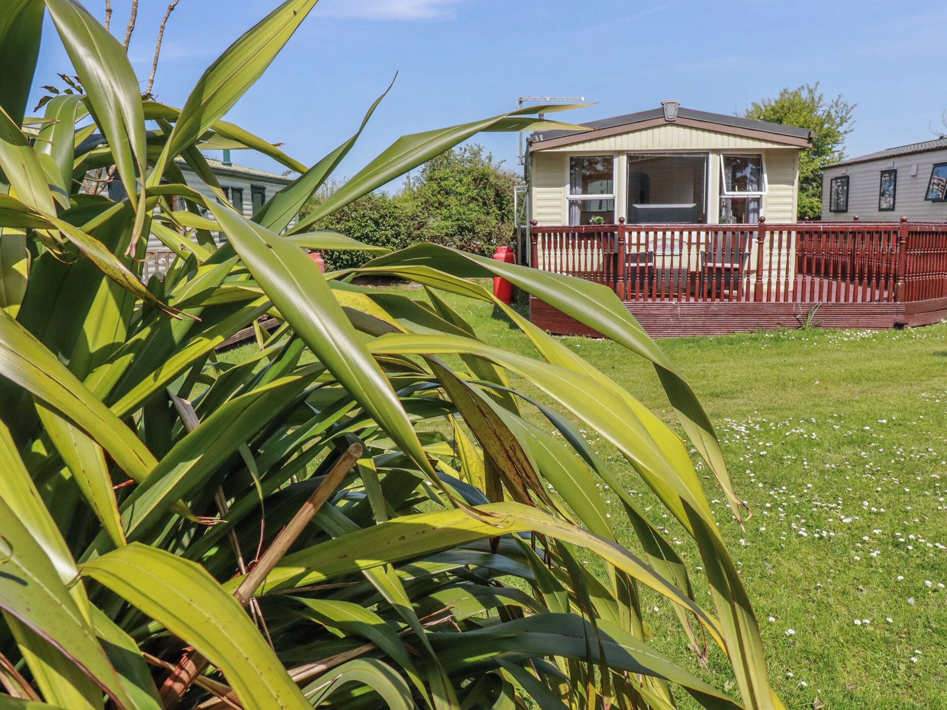 A house with a porch, a fenced yard, and a lawn.