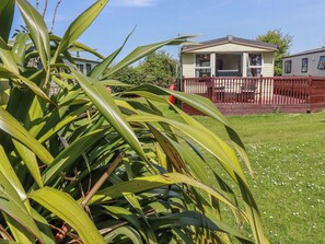 Ein Haus mit Veranda, umzäunter Garten und Rasen.