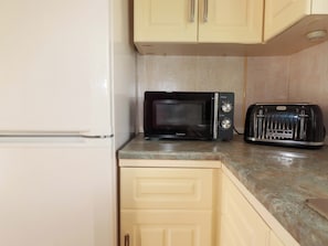 A kitchenette with a microwave, toaster, and a white refrigerator. - Beech Lodge (Wadebridge)