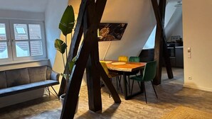 Un coin repas avec une table et des chaises en bois, un banc et une plante en pot.