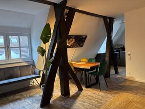 Un coin repas avec une table et des chaises en bois, un banc et une plante en pot.