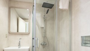 Une salle de bain moderne avec une douche à parois de verre, un lavabo et des toilettes.