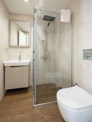 Standaard kamer, uitzicht op tuin | Badkamer | Een douche, gratis toiletartikelen, een haardroger, handdoeken