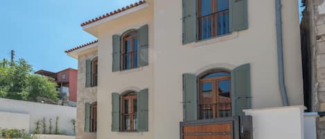 A two-story building with multiple windows and a wooden gate.