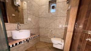 A bathroom with a sink, toilet, and shower. - Jeet residency by twamev (New Delhi)
