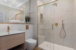Chuveiro, secador de cabelo, toalhas de banho, shampoo