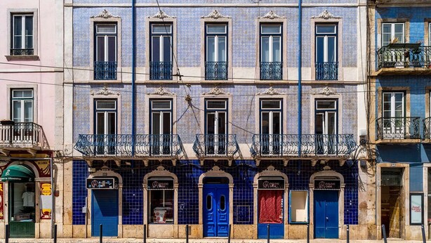 Een rij gebouwen met blauwe betegelde gevels, meerdere ramen en balkons.