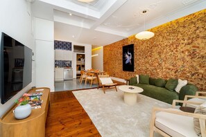 Ein modernes Wohnzimmer mit Flachbildfernseher, Essbereich und Küche.