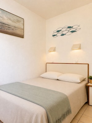 Ein Schlafzimmer mit einem Bett, zwei Wandleuchten, einem Gemälde und einer Wanddekoration.