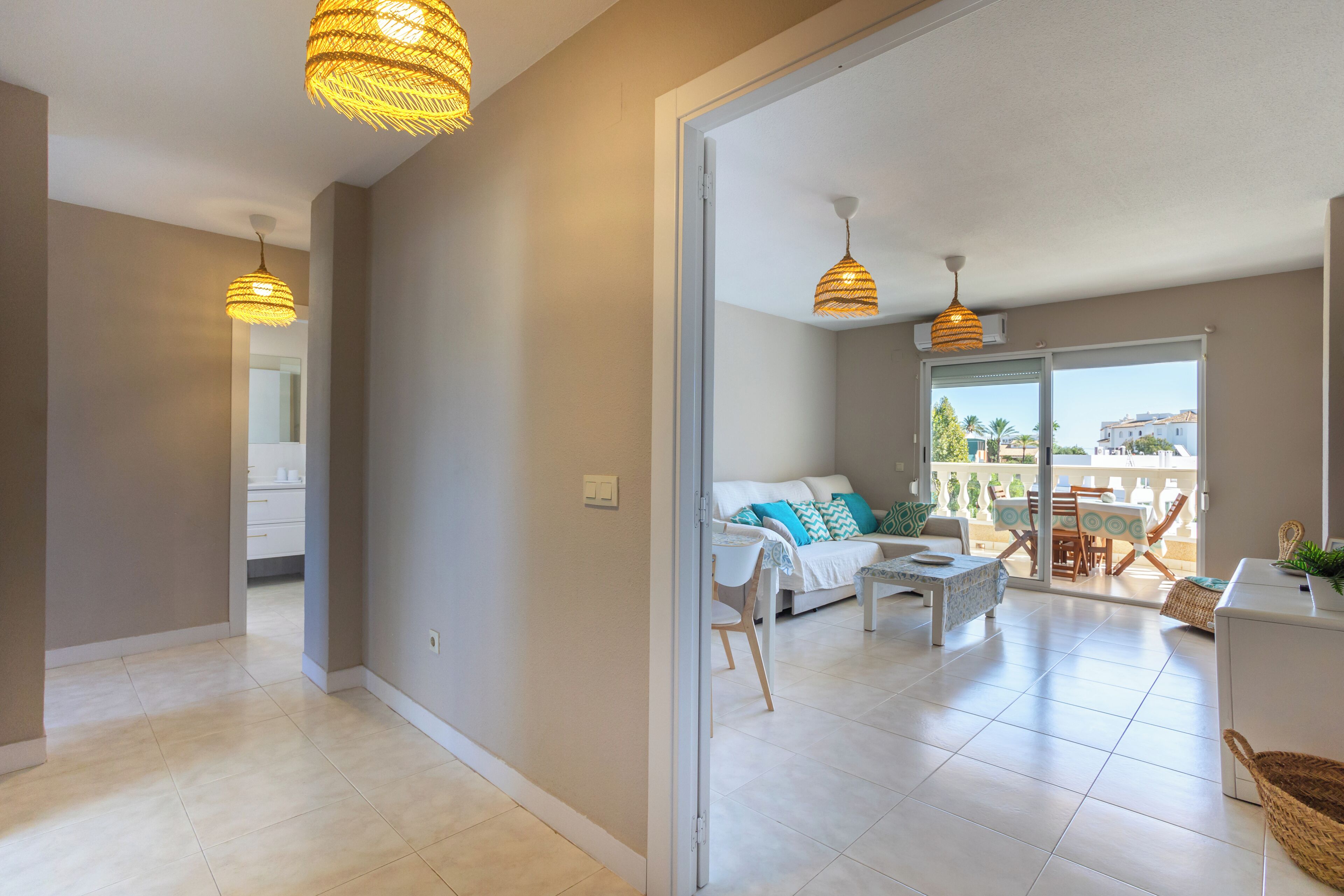 A modern apartment with a living area, dining space, and a balcony with a view.