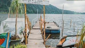 A wooden dock leading to a boat, with a sign indicating 'CATUR LAWA GLAMPING'. - Catur Glamping Bedugul (Baturiti)