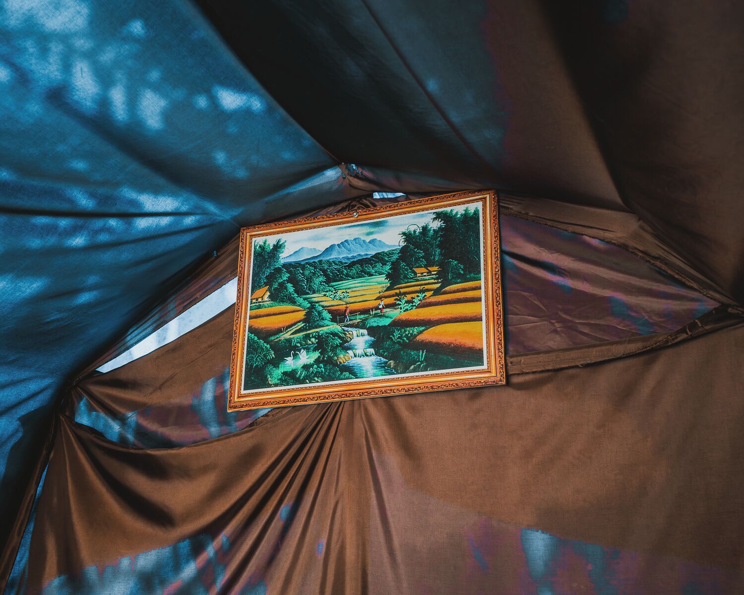 A tent with a framed painting of a landscape.
