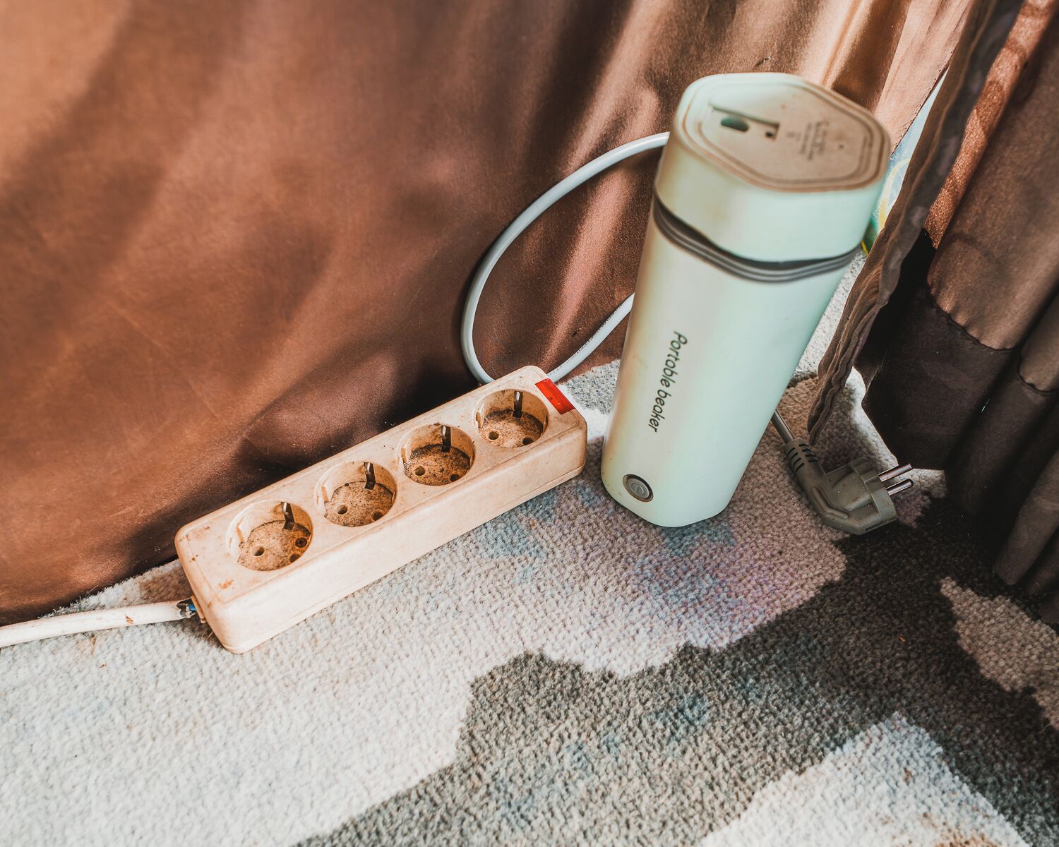 A portable battery charger connected to a power strip with multiple sockets.