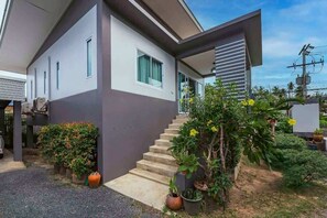 A modern two-story house with a staircase leading to the entrance, surrounded by potted plants and a clear sky. - Villa 9 - Spacious 2 Bedroom Villa with Pool Near Beaches, Dining and Nightlife near Fisherman's Village (Ko Samui District)