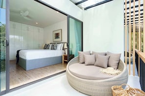 Ein modernes Schlafzimmer mit einem großen Bett, einer Korbschaukel und einer Glastür, die auf einen Balkon führt.