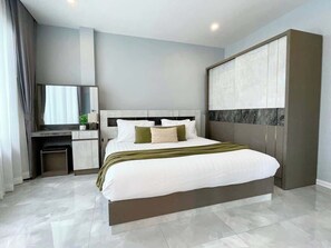 Ein modernes Hotelzimmer mit einem großen Bett, einem Schreibtisch und einem Kleiderschrank.