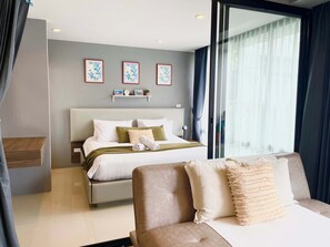 Ein modernes Schlafzimmer mit Bett, einer Couch, einer Glastür und einem an der Wand befestigten Regal mit Bildern.