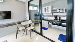 Eine moderne Küche mit Mikrowelle, Kaffeemaschine und Schränken.