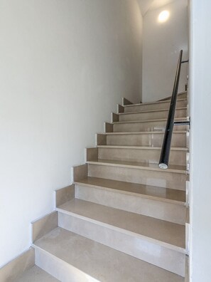 Eine Treppe mit Handlauf, die zu einer oberen Etage führt.