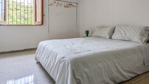 A bedroom with a bed, a window with a view, a hanging light fixture, and a wardrobe. - Sea and Sun House - Sea Option (Vibonati)