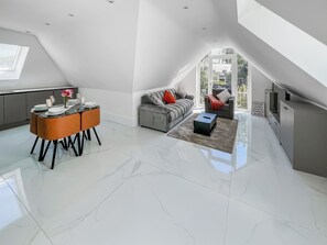 Un loft moderno con comedor, sofá y vistas al exterior.