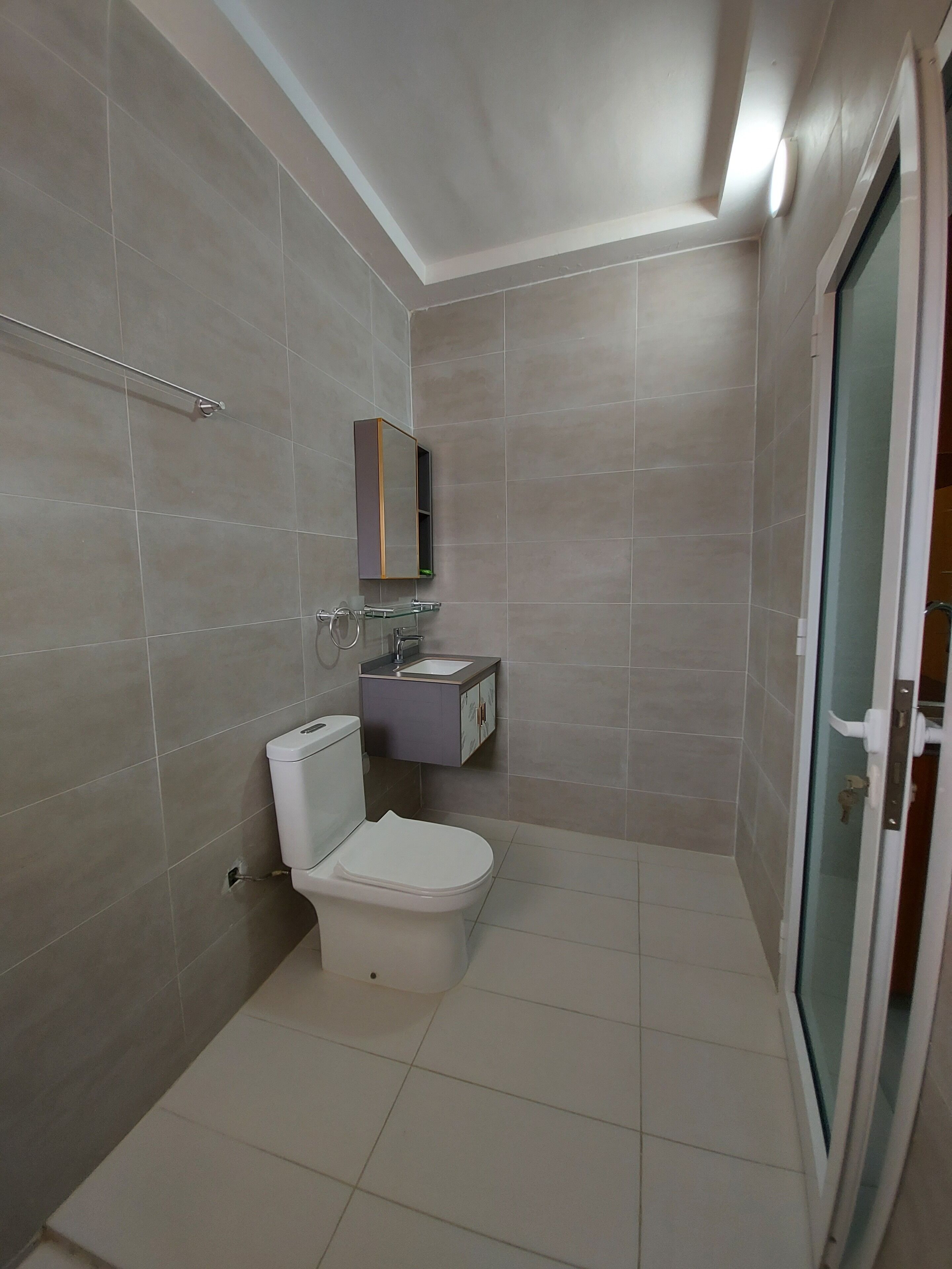 Ein Badezimmer mit Toilette, Waschbecken und Spiegel.