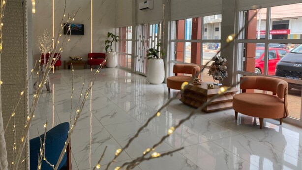 A spacious lobby with a marble floor, modern furniture, and large windows offering views of the outside.