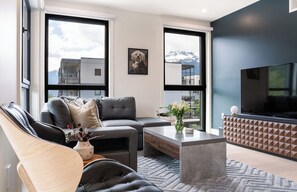 Ein modernes Wohnzimmer mit Sofa, Couchtisch und Fernseher.
