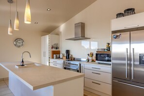 Microwave, stovetop, dishwasher - Miro Ridge in Palm Beach - Miro Ridge is a spacious elevated holiday home overlooking Palm Beach with sea views and generous indoor-outdoor living. Large sliding doors open to an expansive deck, while the open plan lounge and entertainer’s kitchen cr (Waiheke Island)