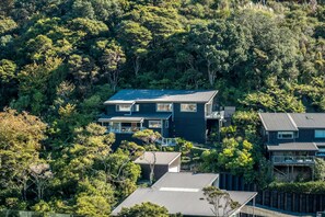 Exterior - Miro Ridge in Palm Beach - Miro Ridge is a spacious elevated holiday home overlooking Palm Beach with sea views and generous indoor-outdoor living. Large sliding doors open to an expansive deck, while the open plan lounge and entertainer’s kitchen cr (Waiheke Island)