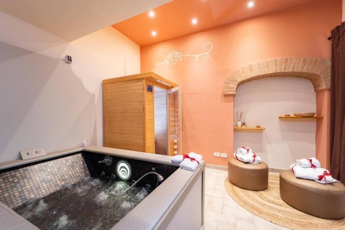 Un cuarto de spa con un jacuzzi, sauna de madera y zona de masajes.
