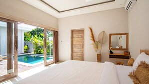 Quarto com uma cama grande, uma porta de madeira, um espelho e vista para uma piscina ao ar livre.