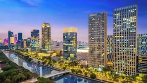 A cityscape with modern high-rise buildings, a river, and a bridge. - Wanhao Max Hotel - Guangzhou Pazhou (Guangzhou)