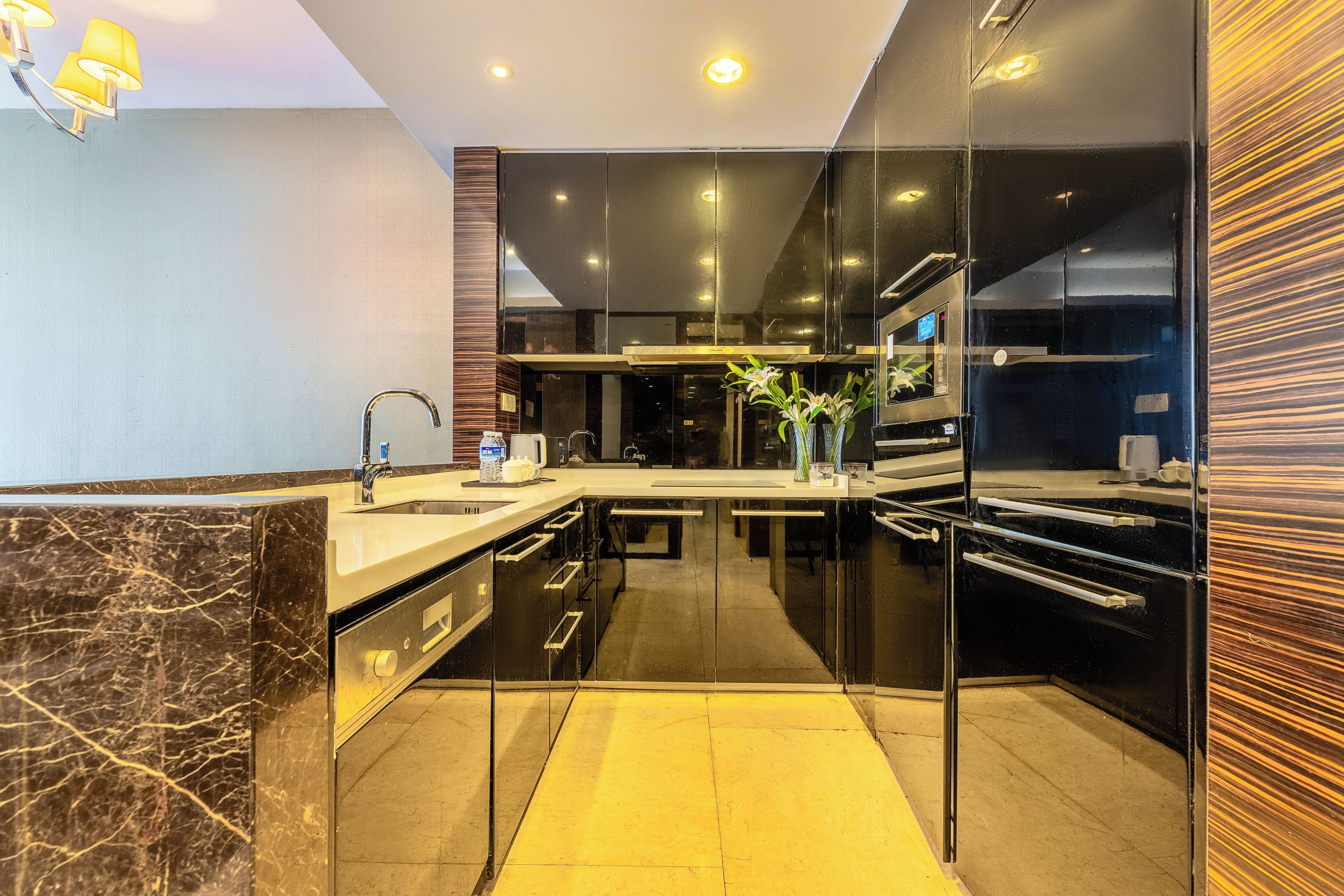 Una cocina moderna con encimera de mármol, electrodomésticos de acero inoxidable y salpicadero de vidrio.